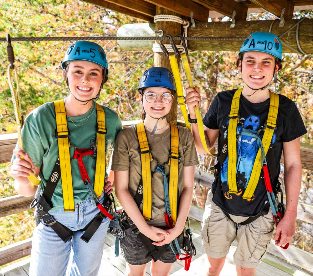 Young people harnessed up to go on a ropes course
